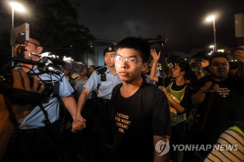 홍콩 '우산 혁명'의 주역이자 '범죄인 인도 법안'(송환법) 반대 시위를 이끄는 조슈아 웡 데모시스토(香港衆志)당 비서장이 지난달 7일 홍콩에서 경찰과 대치하고 있다. 데모시스토당은 조슈아 웡이 30일 경찰에 체포됐다고 밝혔다. 연합뉴스 제공.